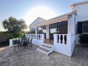 a patio with a table and chairs and a house at Chalet familiar con piscina en Binixica in Binibeca