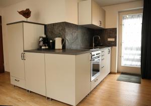 a kitchen with white cabinets and a black counter top at Ferienwohnung Im Münchner - Süden in Schäftlarn