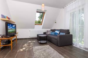 a living room with a couch and a tv at Holiday home in Balatonbereny 42284 in Balatonberény