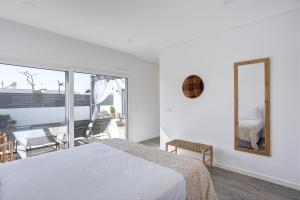 a bedroom with a bed and a mirror and a balcony at Villa Sal - Porto Covo in Porto Covo +43 photos