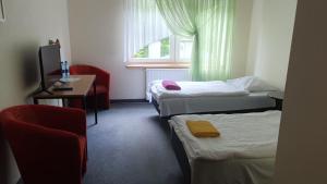 a room with three beds and a chair and a window at Leśny Dwór - śniadanie i parking w cenie in Szczecinek