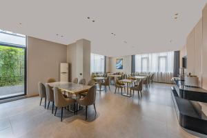 a dining room with tables and chairs and a large window at Joyston Hotel in Guangzhou