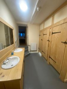 a bathroom with two sinks and wooden cabinets at Lyde Court Country House in Hereford
