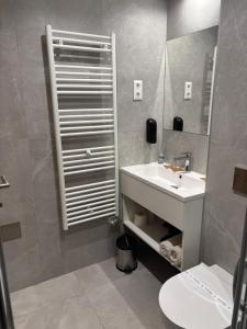 a bathroom with a white sink and a mirror at LIANA Apartman in Sárvár