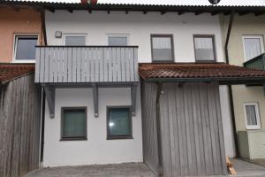 a white building with windows and a fence at Ferienwohnung Eder in Bad Birnbach