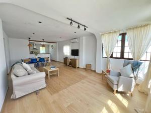 a living room with two couches and a kitchen at Chalet Vacacional ELIÁ -Piscina Privada, BBQ, Wifi in Chiclana de la Frontera