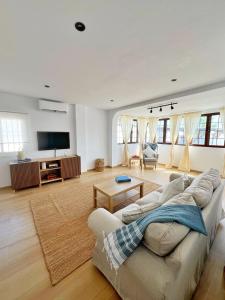 a living room with a couch and a tv at Chalet Vacacional ELIÁ -Piscina Privada, BBQ, Wifi in Chiclana de la Frontera