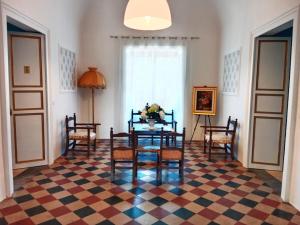a dining room with a table and chairs on a checkered floor at Villa Maggio in Acate