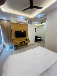 ein Schlafzimmer mit einem großen weißen Bett und einem Flachbildfernseher in der Unterkunft Hotel sapphire in Jāmb