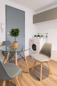 a dining room with a glass table and chairs at Le Cozy - Hyper centre - Calme - Moyenne durée in Épinal +5 photos