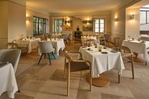 a restaurant with white tables and chairs in a room at La Bastide de Mougins, a Tribute Portfolio Hotel in Mougins