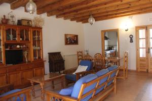 a living room with blue chairs and a television at Casa Rural El Alfar in Tajueco