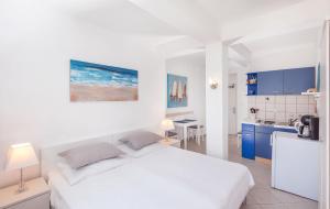 una camera da letto con un letto bianco e una cucina di Apartments Mirela a Mlini