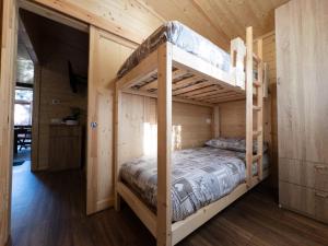 a bedroom with a bunk bed in a wooden cabin at Campeggio Beaulard in Beaulard