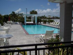 a large swimming pool with chairs and a table and avisor at Lighthouse Inn at Aransas Bay in Rockport