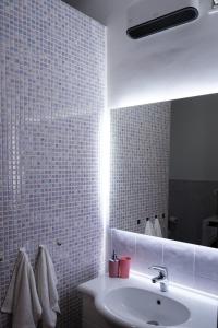 a bathroom with a sink and a mirror at Le 3 Onde apartment 300 meters from the beach in Salerno