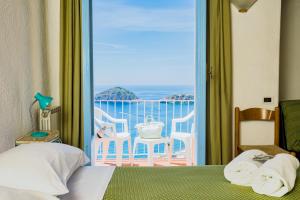 a bedroom with a bed and a view of the ocean at Hotel Sunset Green in Ischia