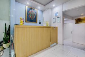 a lobby with a reception desk and a door at Hotel O Tegal near near Pacific Mall Tegal formerly Hugo Suites Family in Tegal