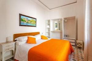 a bedroom with a bed with an orange blanket at Villa Alimede in Positano