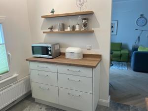 a kitchen with a microwave on top of a dresser at Ferienwohnung Rheiderland in Weener