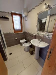 un bagno con lavandino, WC e specchio di Arena Vacanze a Castellabate Altre 39 foto