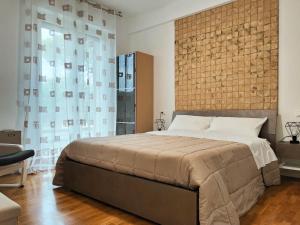 Un dormitorio con una cama grande y una pared de ladrillo. en Bastia Home Plus, en Bastia Umbra