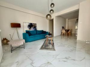 a living room with a blue couch and a table at Cornelia Lux Suites by Horizon Homes in Ofrínion