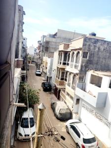 deux voitures garées dans une rue de la ville avec des bâtiments dans l'établissement Mini Studio tres chic, à Dakar