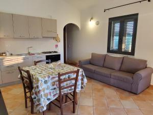 ブドーニにあるCasa vacanze in budoni San lorenzoのテーブルとソファのあるリビングルーム