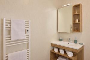 a bathroom with a sink and a mirror and towels at Quality Suites Cholet in Cholet +32 photos