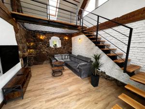 a living room with a couch and a staircase at Miejski Las 8 in Mrągowo