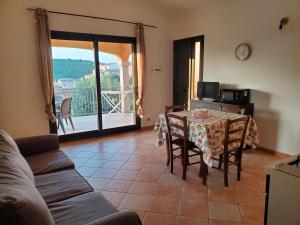 ブドーニにあるCasa vacanze in budoni San lorenzoのリビングルーム(テーブル付)、バルコニー +9枚の写真