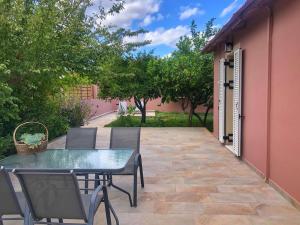 a patio with a table and chairs and trees at Avli Cottage in Sami