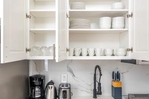 a kitchen with white cabinets and dishes on the shelves at Blueground Midtown West wd nr Broadway NYC-1863 in New York
