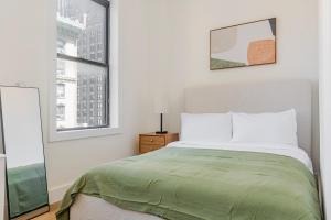 a white bedroom with a bed and a window at Blueground Midtown West wd nr Broadway NYC-1863 in New York