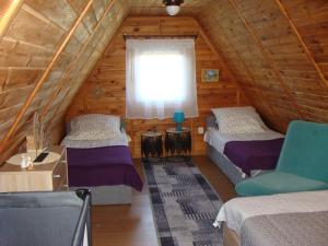 Habitación en el ático con 2 camas y ventana en Domki u Uli, en Jarosławiec
