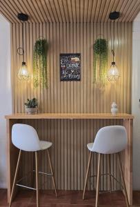 two white chairs sitting in front of a bar at El Nogal Home in Málaga