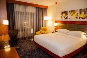 a hotel room with a large bed and a chair at Hilton Garden Inn Nairobi Airport in Nairobi