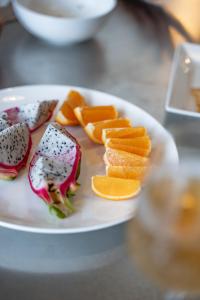 ein weißer Teller mit Essen auf einem Tisch in der Unterkunft Dei Amami in Amami