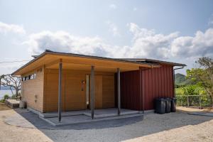 ein kleines Haus mit einem roten Gebäude in der Unterkunft Dei Amami in Amami