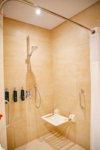 a bathroom with a shower with a shower seat at Hilton Garden Inn Nairobi Airport in Nairobi