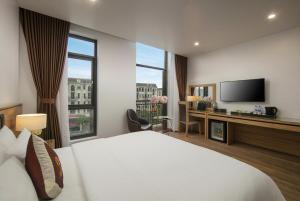 a hotel room with a bed and a television at Lam Anh Hotel 5 Him Lam Vạn Phúc in Hà Ðông