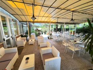 ein Restaurant mit weißen Stühlen und Tischen und Fenstern in der Unterkunft Hotel Fiorenza in Milano Marittima