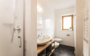 a white bathroom with a sink and a toilet at Oberhuberhof in Rodengo +30 photos