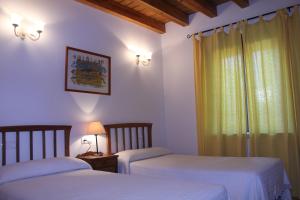 a bedroom with two beds and a window at Casa Rural El Alfar in Tajueco
