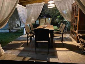 a table and chairs on a patio with curtains at Villa Doble M in Cervera de Pisuerga