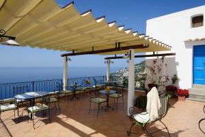 a patio with tables and chairs under an umbrella at La Casa Del Melograno in Furore