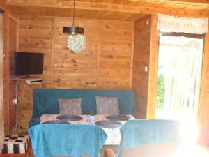 Una sala de estar con un sofá azul y una mesa. en Domki u Uli, en Jarosławiec