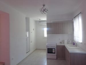 a white kitchen with a sink and a stove at Antiparos Diamond in Antiparos