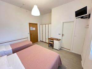 ein Hotelzimmer mit zwei Betten und einem Flachbildfernseher in der Unterkunft Hotel Fiorenza in Milano Marittima